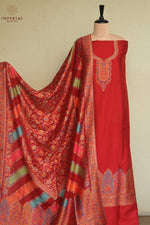 A red three-piece women's salwar suit set displayed on a mannequin, featuring a solid red kurta with ornate gold embroidery, a matching red salwar, and a highly patterned red dupatta with gold, green, and blue accents. Kashmiri Kani Suit 