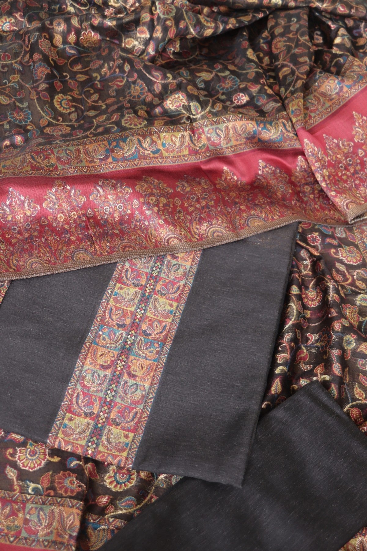 patterned Salwar suit fabric with intricate designs in red, black, and gold